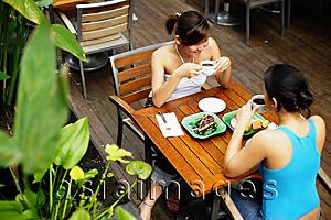 Asia Images Group - Two women at cafe, having coffee and food, high angle view