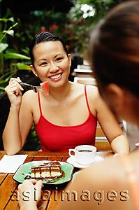 Asia Images Group - Women at cafe, eating, over the shoulder view