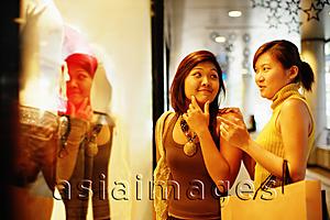Asia Images Group - Young women looking at window display, talking