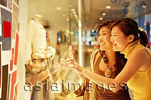 Asia Images Group - Young women, standing outside window display, looking in