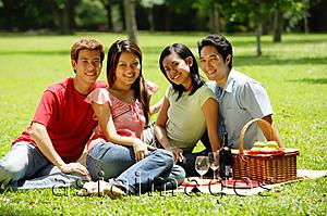 Asia Images Group - Young adults sitting in park, looking at camera, portrait