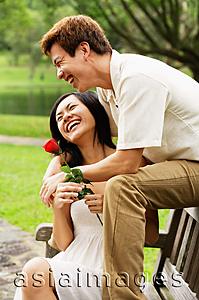Asia Images Group - Couple on park bench, woman holding a rose, smiling