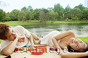 Asia Images Group - Couple lying on mat in park