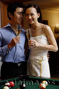 Asia Images Group - Couple standing side by side, holding champagne glasses