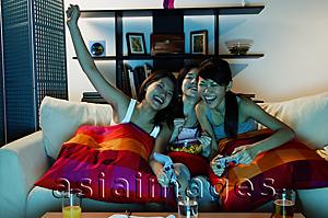 Asia Images Group - Young women in living room, playing video games