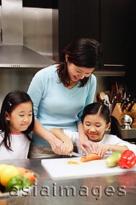 Asia Images Group - Mother with two daughters in kitchen