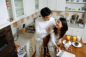 Asia Images Group - Couple in kitchen, man massaging womans shoulder