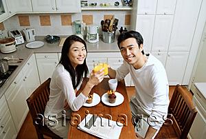 Asia Images Group - Couple in kitchen, having breakfast, smiling at camera