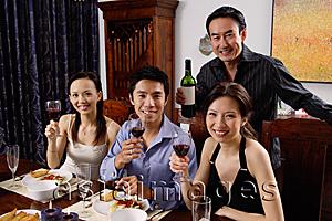 Asia Images Group - Adults at dining table, smiling at camera, raising wine glasses