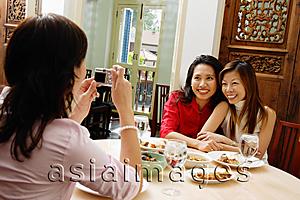 Asia Images Group - Woman holding camera, taking pictures of friends