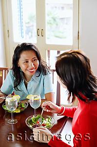 Asia Images Group - Women sitting at a cafe, eating salad