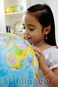 Asia Images Group - Young girl looking at globe, smiling