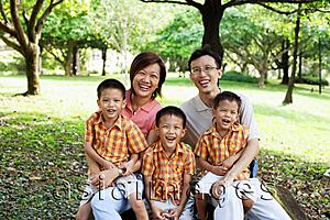 Asia Images Group - Family with three boys in park, smiling at camera