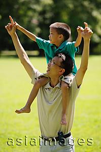 Asia Images Group - Father carrying son on shoulders, pointing up
