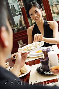 Asia Images Group - Man holding plate of food, woman taking from it