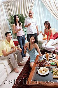 Asia Images Group - Adults in living room, smiling at camera, social gathering