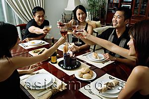 Asia Images Group - Adults toasting with wine glasses across dining table