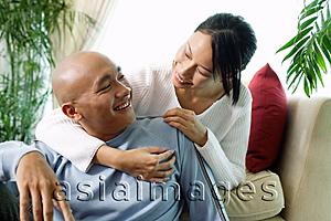 Asia Images Group - Couple in living room, woman with arm around man