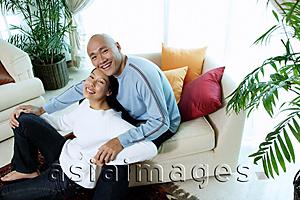 Asia Images Group - Couple in living room, looking up at camera