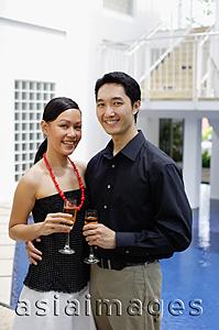 Asia Images Group - Couple by poolside, holding champagne glasses