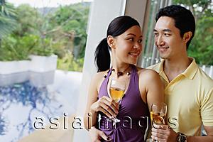 Asia Images Group - Couple holding wine glasses, looking at each other