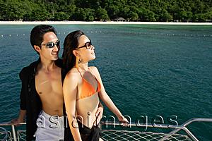 Asia Images Group - Couple on boat deck, looking away