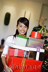 Asia Images Group - Woman carrying pile of gifts