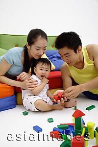 Asia Images Group - Father, mother and son sitting in living room, playing with wooden toy blocks
