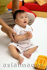 Asia Images Group - Baby boy sitting on floor, father supporting him