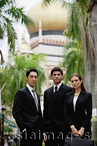 Asia Images Group - Two businessmen and one businesswoman standing together, looking at camera