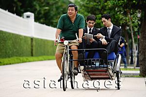 Asia Images Group - Businessmen riding in trishaw