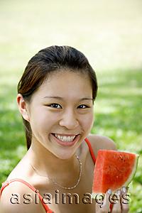 Asia Images Group - Woman holding slice of watermelon