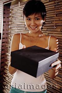 Asia Images Group - Young woman holding box, looking at camera