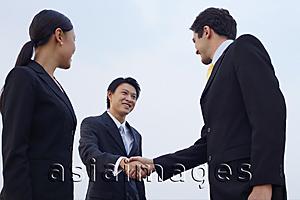 Asia Images Group - Businesspeople shaking hands, low angle view