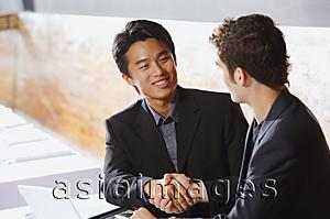 Asia Images Group - Two men sitting, shaking hands