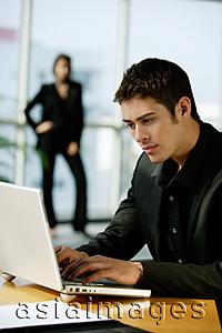 Asia Images Group - Male executive dressed in black, using laptop