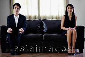 Asia Images Group - Man and woman sitting apart on sofa