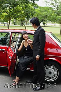 Asia Images Group - Man helping woman out of car