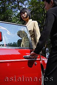 Asia Images Group - Man opening door of car for woman