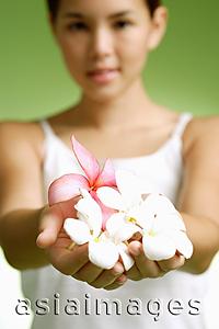 Asia Images Group - Young woman holding flowers in cupped hands