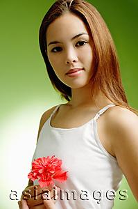 Asia Images Group - Young woman holding Hibiscus flower, looking at camera