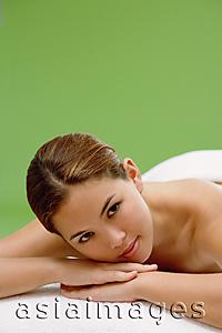 Asia Images Group - Young woman lying on massage table, head on arms