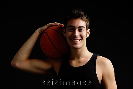Asia Images Group - Man holding basketball on shoulder, smiling at camera