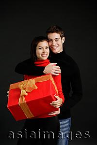 Asia Images Group - Woman holding gift, man embracing her