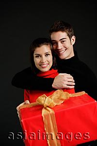 Asia Images Group - Woman holding red gift, man embracing her
