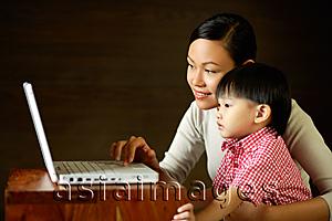 Asia Images Group - Mother with young son, looking at laptop