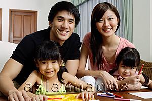 Asia Images Group - Family of four at home, looking at camera