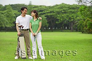 Asia Images Group - Couple on golf course, smiling at each other