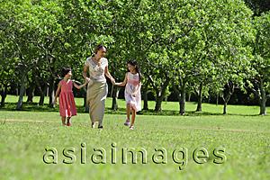 Asia Images Group - Mother and two daughters holding hands, walking across park