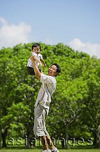 Asia Images Group - Father lifting son in the air, both looking at camera